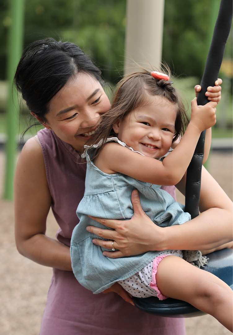 Photo of a child and parent playing on a playground
