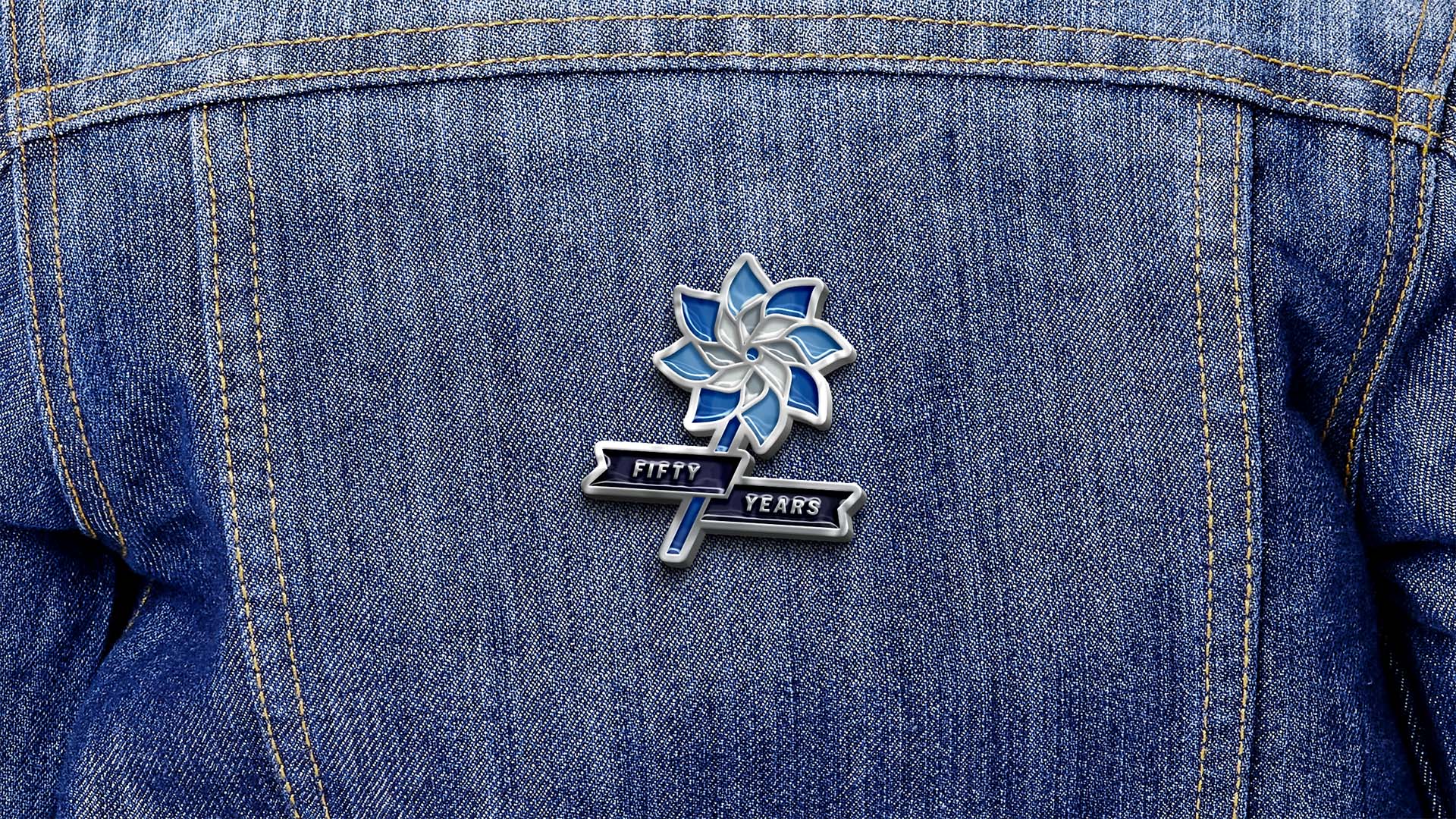 A enamel pin of the Prevent Child Abuse America 50th anniversary logo on a jean jacket